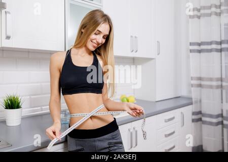 Slim Athletic Brunette Girl misurando la sua vita Foto Stock