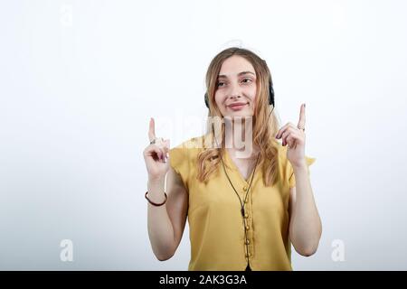 Attraente giovane donna dancing, avente le cuffie di Nizza sulla testa, sorridente Foto Stock