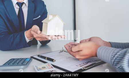 Rappresentante di vendita offrono acquisto casa contratto per acquistare una casa o un appartamento o per la discussione circa i prestiti e i tassi di interesse Foto Stock