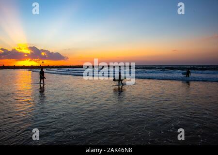 Silhouette di surfisti sulla spiaggia del mar Mediterraneo. Fotografato a Tel Aviv al tramonto Foto Stock