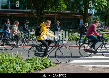 Persone a cavallo bicyle in città in una giornata di sole Foto Stock