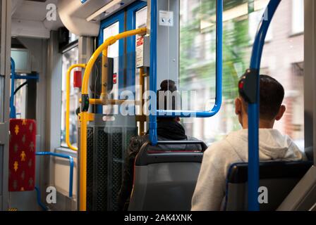 Le persone all'interno dell'autobus che vanno da qualche parte e che guardano attraverso la finestra Foto Stock