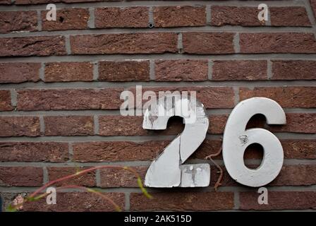 Numero 26 su un muro di mattoni Foto Stock