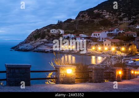 Chiessi, Isola d'Elba, Toscana, Italia. Bellissima vista del villaggio al tramonto. Macchia mediterranea, case e alberghi con le luci gialle il Foto Stock