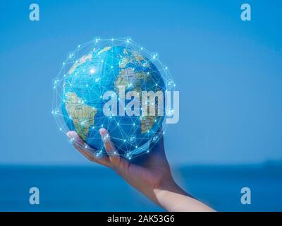 Tenendo le mani a livello globale con la comunicazione e la rete sociale di sfondo del mare. la comunicazione e il concetto di rete. Foto Stock