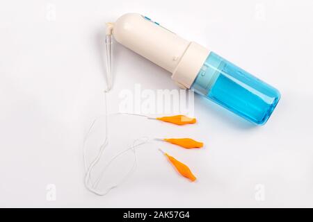 Igiene orale Prodotti. Irrigatore, ruffs per spazzolare i denti e il filo interdentale su sfondo bianco Foto Stock