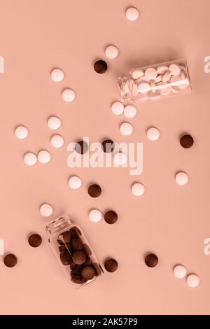 Bianco e Marrone di compresse e bottiglie disseminate su corall sfondo, vista dall'alto, il concetto di medicina Foto Stock