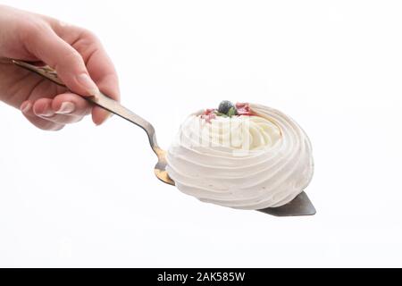 La torta su una pala di pasticceria in un canto isolato su uno sfondo bianco Foto Stock