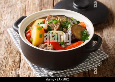 Stufato di agnello con melanzane e patate Chanakhi in una pentola di close-up sul tavolo orizzontale. Foto Stock