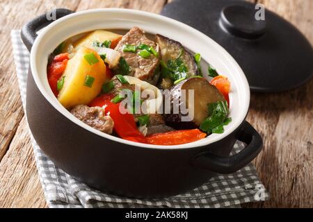 Chanakhi è un tradizionale piatto georgiano di stufato di agnello con pomodori, melanzane, patate, verdure e aglio vicino sul tavolo. Posizione orizzontale Foto Stock