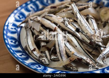 Paksiw na dilis è un piatto filippino di acciughe a fuoco lento nell'aceto con spezie come aglio, cipolla e zenzero. Foto Stock