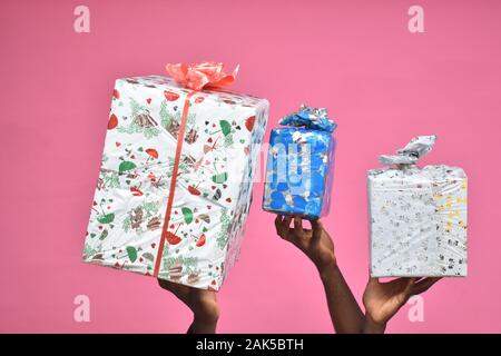 Confezioni regalo portato nello spazio da due persone nere, solo le mani Foto Stock