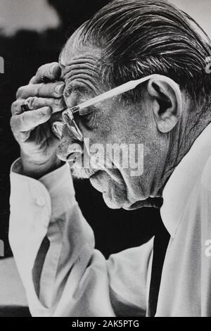 Fine anni '70 nero e bianco annata fotografia di un uomo più anziano che furrowing la sua fronte e la lettura di qualcosa Foto Stock