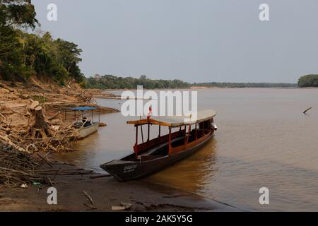 Tipica barca nella giungla sulle rive del fiume Amazonas con sfondo giungla nel Parco Nazionale di Tambopata (Perù, Sud America) Foto Stock