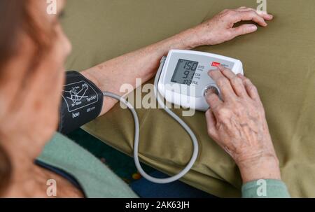 Vecchia donna la misura della pressione del sangue, la misurazione della pressione sanguigna, senior citizen, Germania Foto Stock