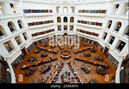 Cupola sala lettura in biblioteca dello Stato di Victoria, Melbourne Australia, con studenti prigionieri e la lettura con archi libri sugli scaffali Foto Stock