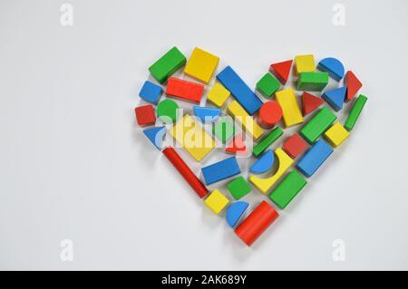 In legno colorato blocchi giocattolo sagomatura della forma di un cuore Foto Stock