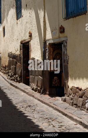 Piccolo vicolo nella colorata città di Cusco nelle Ande peruviane con le sue pittoresche case arancioni, strade antiche e ornamenti in pietra (Cusco, Perù) Foto Stock