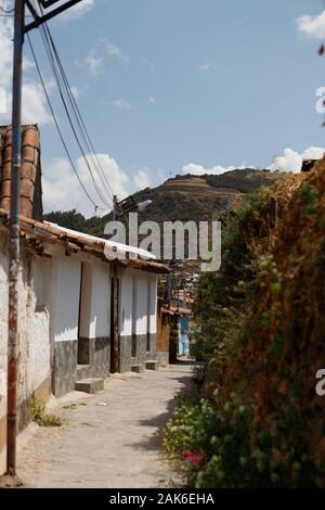 Piccolo vicolo nella colorata città di Cusco nelle Ande peruviane con le sue pittoresche case arancioni, strade antiche e ornamenti in pietra (Cusco, Perù) Foto Stock