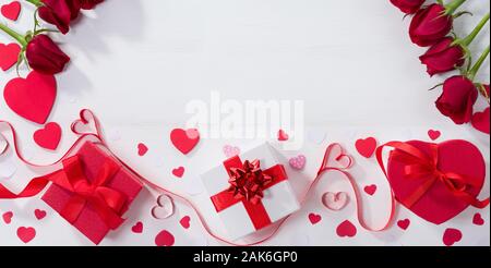 Confezioni regalo, nastro cuori e rose sul tavolo bianco. Il giorno di San Valentino idea regalo Foto Stock