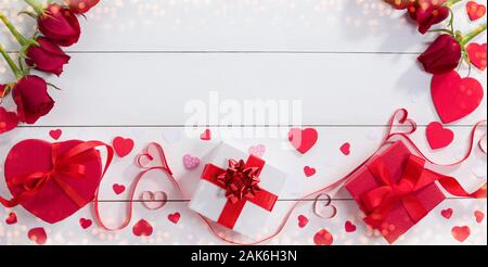 Confezioni regalo, nastro cuori e rose sul tavolo bianco. Il giorno di San Valentino idea regalo Foto Stock