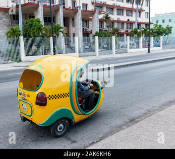 L'Avana, Cuba - 25 Luglio 2018: giallo taxi scooter guidando lungo la strada a Cuba il trasporto di turisti verso la propria destinazione. Foto Stock