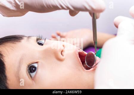 Il dentista esaminando little boy denti nella clinica dentale. Foto Stock