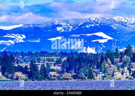 La costruzione di case di gru quartieri residenziali il Lago Washington Snow capped Cascade Mountains Bellevue Washington Foto Stock