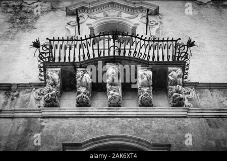 Grottesque maschere, balcone di Palazzo Cosentini, Ragusa Ibla, Sicilia, Italia Foto Stock