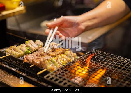 Fornitore preparare la carne su barbecue grill in Giappone Foto Stock