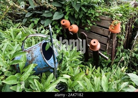 Giardino sovradimensionate, acqua può, fioriere sul recinto, compostiera in legno Foto Stock