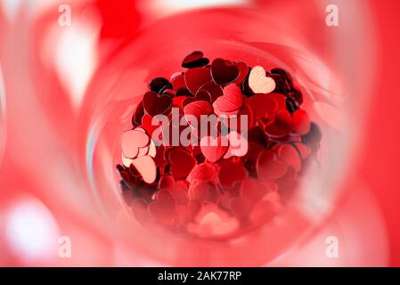 Cuori rossi sono sparsi in un bicchiere. Il giorno di San Valentino concetto Foto Stock