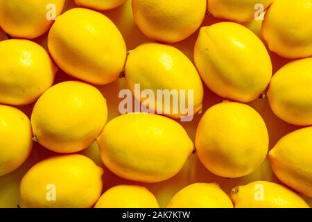 Vista superiore molti limoni maturi su una superficie di colore giallo, lo sfondo o il concetto Foto Stock