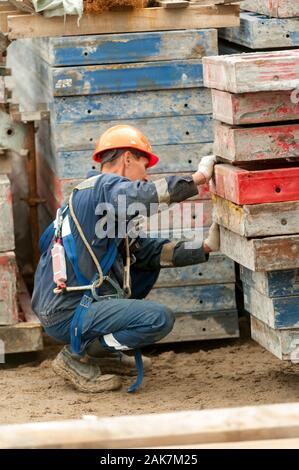 Costruttore in uniforme e casco funzionante con gru Foto Stock