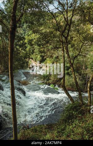 Cascata la caduta massi in mezzo a lussureggianti foreste in un giorno nuvoloso al Caracol parco vicino Canela. Un piccolo e affascinante città nel sud del Brasile. Foto Stock