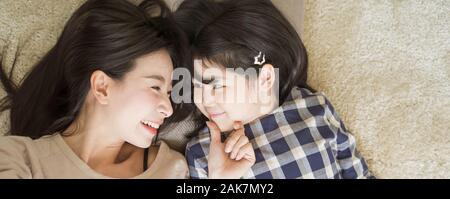 Madre e figlia bambino ragazza di trascorrere del tempo insieme in camera da letto guardano a vicenda e sorridente .felice famiglia asiatica Foto Stock