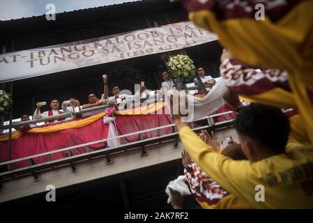 I sacerdoti spruzzare acqua santa sulla folla durante la parata. Migliaia di devoti cattolici partecipano a una sfilata davanti alla Festa del Nazareno nero su 7 Gennaio a Manila nelle Filippine. Milioni di persone sono attese per unire il culmine della festa il 9 Gennaio, dove i devoti Cattolici sarà vie a toccare una vita-dimensioni scultura di un oscuro scuoiati Gesù Cristo - il Nazareno nero - come hanno marciato per le strade di Manila. Le Filippine è uno dei due soli cattolici maggioranza di paesi del sud-est asiatico, accanto a Timor est.Migliaia di Cattolici Romani devoti di partecipare a una sfilata davanti a Foto Stock