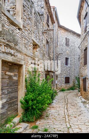 Uno stretto vicolo lastricato tra vecchi edifici nel centro storico della cittadina nella balla, una piccola cittadina collinare sul Mont Pélerin in Istria, Croazia Foto Stock