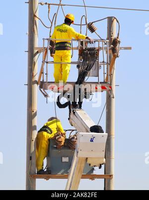 Lavori di manutenzione dell'elettricità in corso di giorno. Questo tipo di lavoro è molto rischioso e dovrebbe essere fatto solo da un dipendente esperto Foto Stock