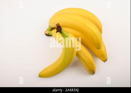 Mazzetto di maturazione delle banane gialle su uno sfondo bianco. Close up Foto Stock