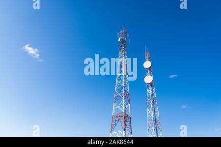 Colorato Disponibile rete telefonia mobile telecommunication torre contro il cielo blu. Foto Stock