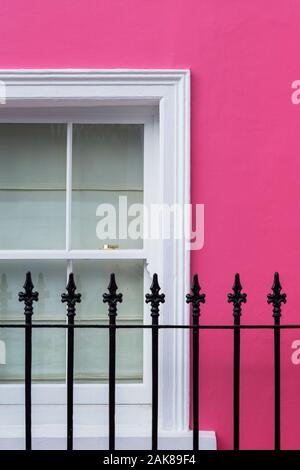 Rosa colorata casa a schiera, finestra e ringhiere in ferro battuto astratta. Chelsea, Royal Borough di Kensington e Chelsea, Londra, Inghilterra Foto Stock