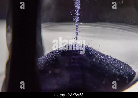 Chiuso di vetro smerigliato o clessidra con sabbia viola e viola Foto Stock