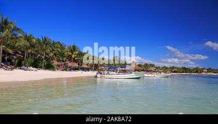 Akumal Bay e dei Caraibi spiaggia bianca compresi barche da pesca in Riviera Maya, costa dello Yucatan, Quintana Roo, Messico Foto Stock