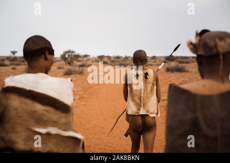 Originale dai Boscimani della Namibia con abbigliamento tradizionale da dietro Foto Stock