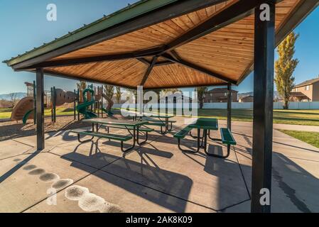 Verde di panche e tavoli in un parco urbano Foto Stock