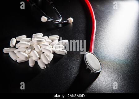 Sfondo nero con stetoscopio, mangiare sano evita di prendere medicinali. Foto Stock