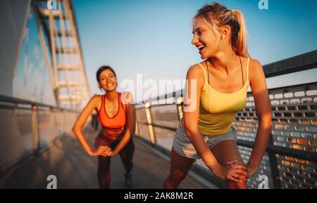 Fitness, sport, persone che esercitano e uno stile di vita sano concetto. Felice montare gli amici che lavora fuori Foto Stock