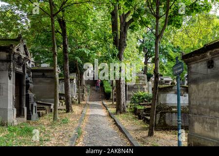 Parigi, Francia: la gente camminare in un vicolo con alberi e tombe nel cimitero di Pere Lachaise in una giornata di sole di settembre. Foto Stock
