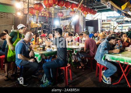 Bangkok, Tailandia - 28 dicembre 2019: Persone mangiano cibo di strada in Bangkok Chinatown intorno Yaowarat street in Thailandia la città capitale di notte Foto Stock